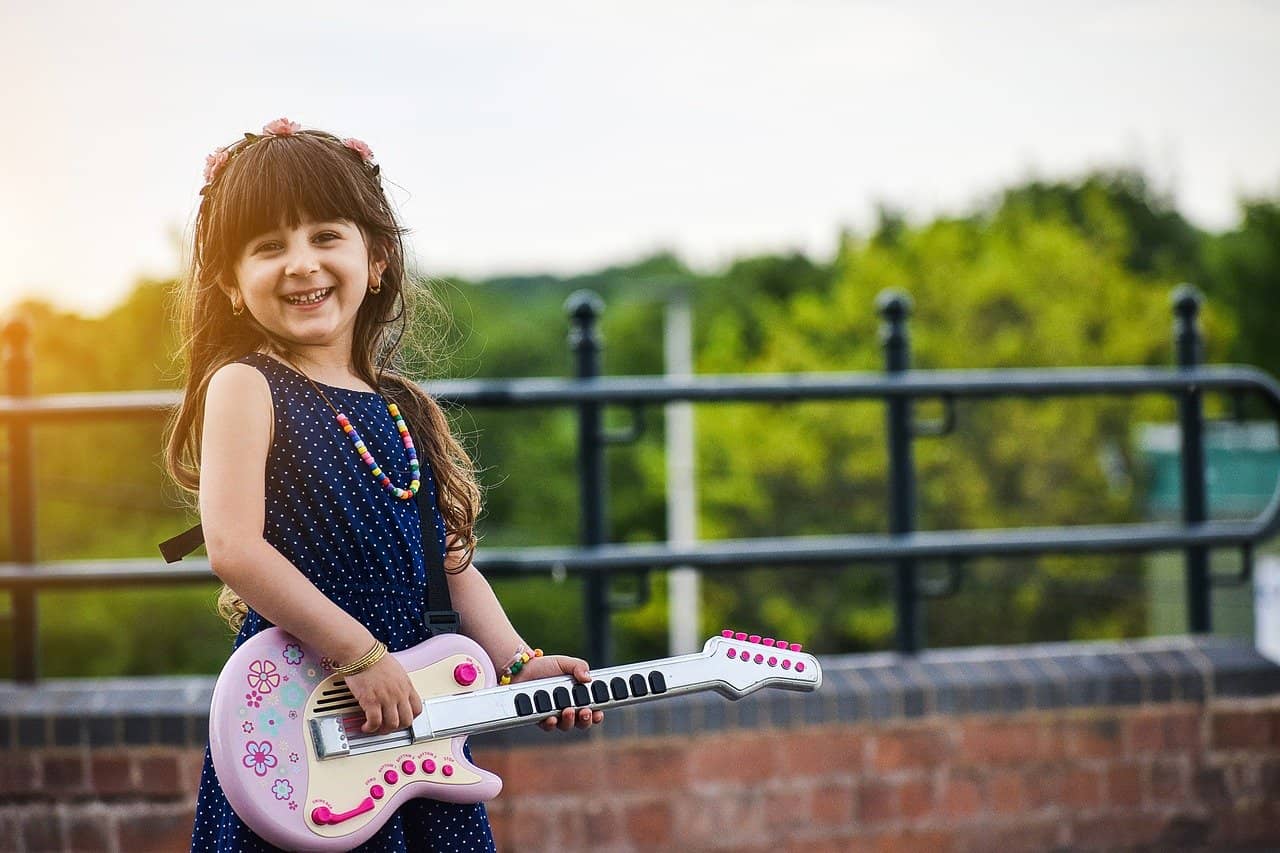 niña tocando guitarra de juguete